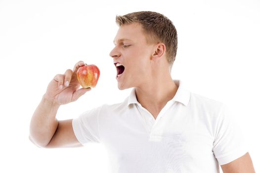 handsome man going to eat apple against white background