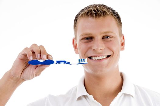 smiling male showing tooth brush on an isolated white background