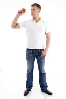 standing male looking at apple against white background