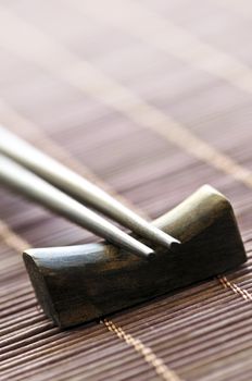 Set of wooden chopsticks on rest close up