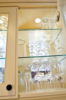 Kitchen cabinet close up with glass shelves and glasses