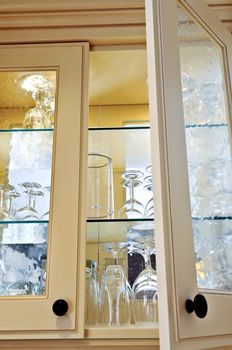 Kitchen cabinet close up with glass shelves and glasses