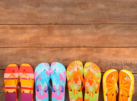 Brightly colored flip-flops on wood deck