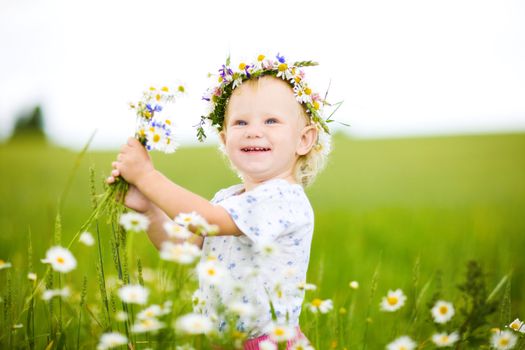 happy small girl with field flowers