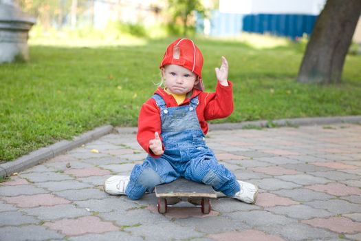 child of 2 years old sitting on the skateboard
