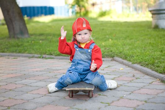 child of 2 years old sitting on the skateboard
