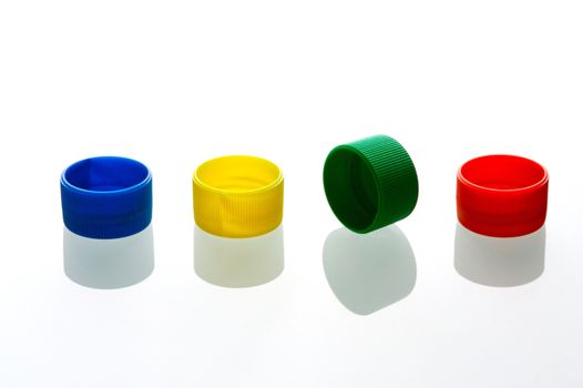 Coloured bottle tops isolated against a white background