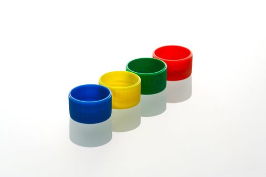 Coloured bottle tops isolated against a white background