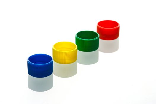 Coloured bottle tops isolated against a white background