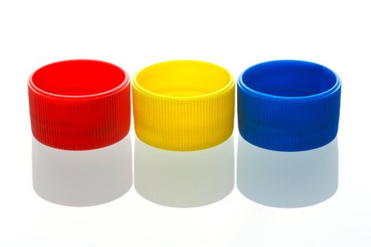 Coloured bottle tops isolated against a white background