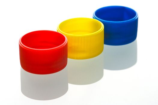 Coloured bottle tops isolated against a white background