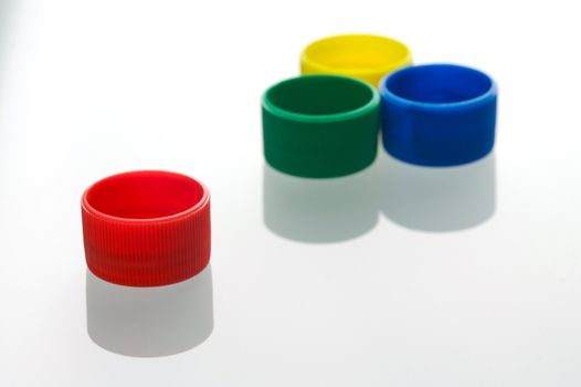 Coloured bottle tops isolated against a white background
