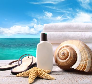 Sunblock lotion and white towels with ocean scene