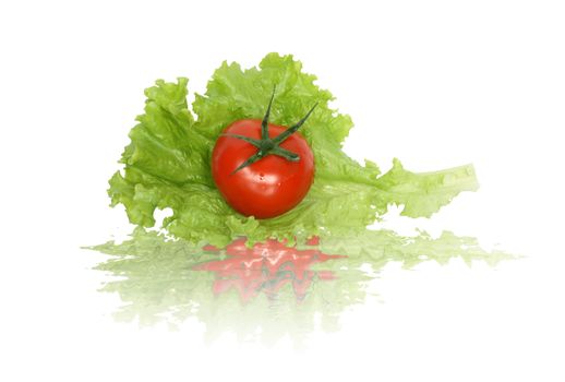 Fresh tomato lying on green lettuce leaf. Isolated on white with clipping path