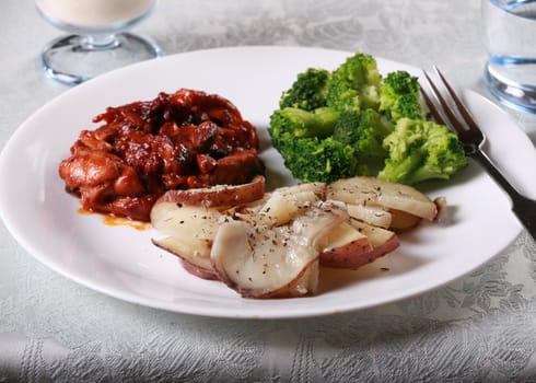 Delicious barbecue chicken meal with side of broccoli and potatoes