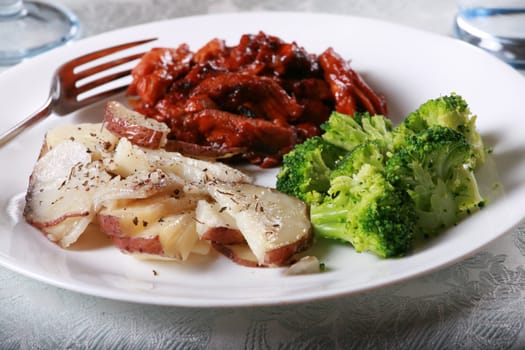 Delicious barbecue chicken meal with side of broccoli and potatoes