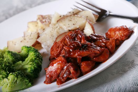 Delicious barbecue chicken meal with side of broccoli and potatoes