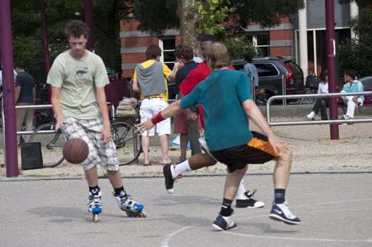 Guys are playing basket on a cement field