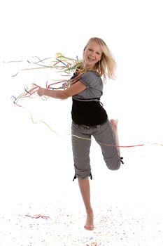 Cute blond young teenage girl dancing on a floor covered in confetti