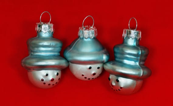 Three Christmas Tree Decoration Snowmen on Red Background