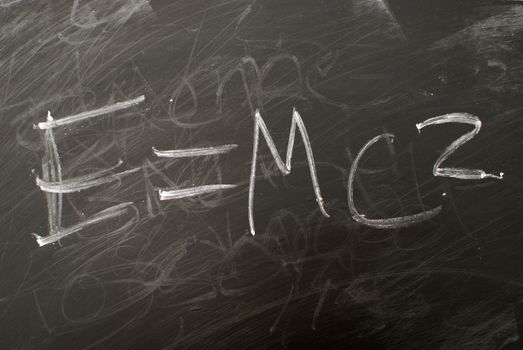 Albert Einsteins famous matematical equation e=mc2 written on a chalkboard.