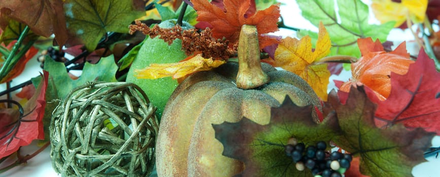 A border or panoramic image of pumpkins and other fake fall ornaments