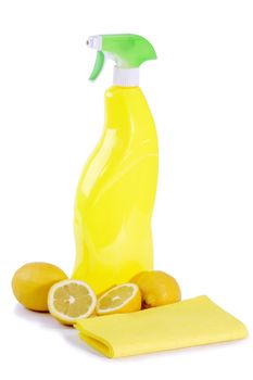 A yellow bottle of household cleaner spray with fresh lemons on bright background