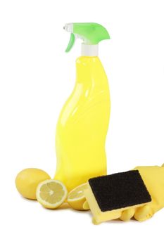 A yellow bottle of household cleaner spray with fresh lemons on bright background