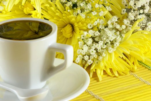 morning cup of coffee with flowers on the table. Shallow DOF