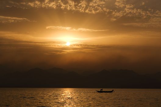 sunset on the lake with a fisherman