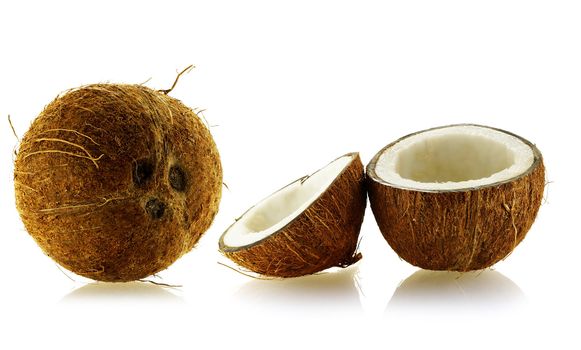 set of whole and cut coconuts over white background