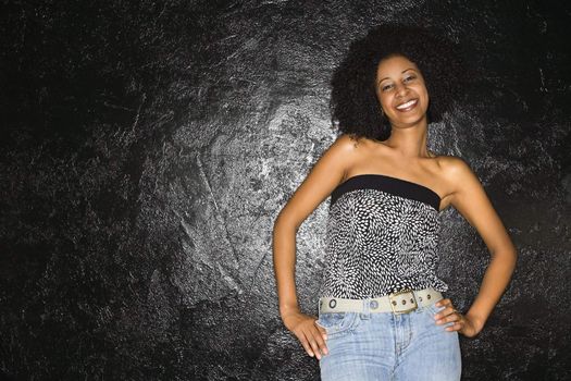 African-American woman standing with hands on hips.