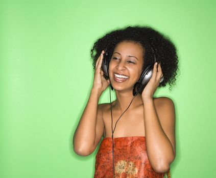 African-American woman listening to music through headphones.