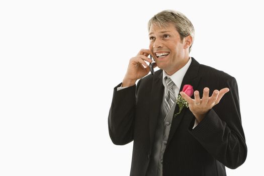 Caucasian groom talking on cellphone.