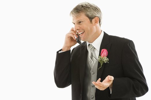 Caucasian groom talking on cellphone.