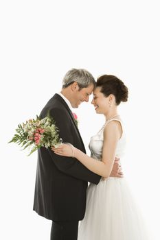 Portrait of Caucasian groom and Asian bride embracing