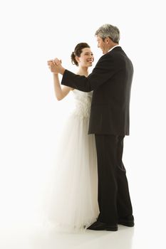 Portrait of Caucasian groom and Asian bride dancing.