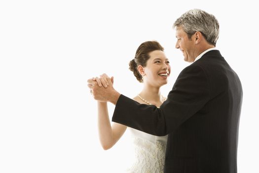 Portrait of Caucasian groom and Asian bride dancing.