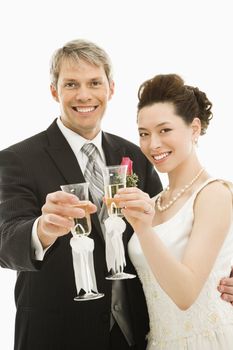 Caucasian groom and Asian bride toasting with champagne glasses.