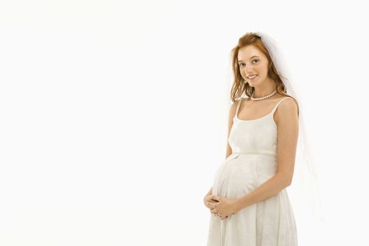 Pregnant Caucasian bride with hands on her belly.