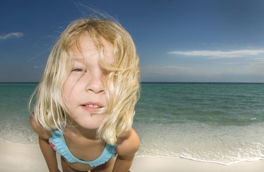 Child looking into the camera on a beautiful sunny day at the beach