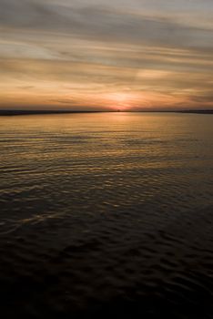 Sunset over a sandbar with ripples in the water