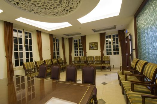 A large mahogany conference room table with leather chars
