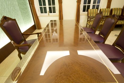 A large mahogany conference room table with leather chars

