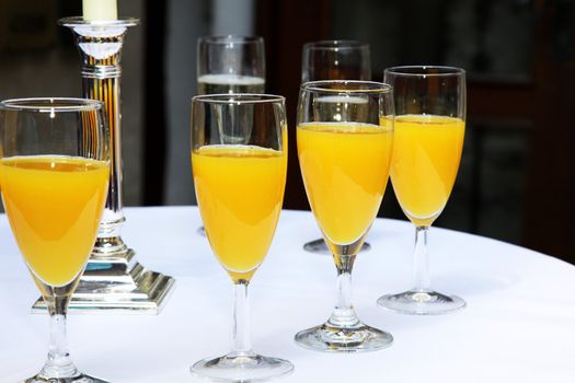 four glasses of fresh orange juice in a row