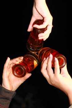 three glass with beer in women hands on black background