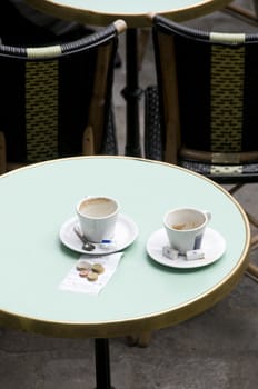 empty coffee cups and bill at cafe, Paris, France