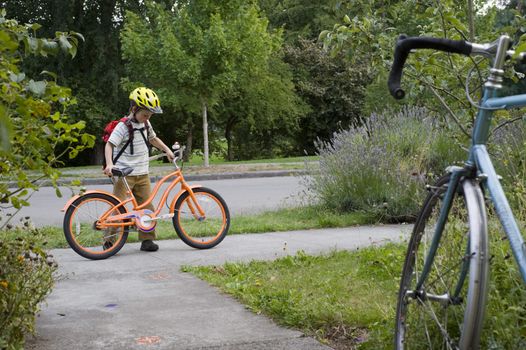 young boy with orange bike, adult bike foreground