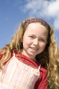 looking up at smiling girl, blue sky behind