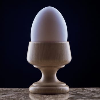 Egg in Wooden Cup on Black